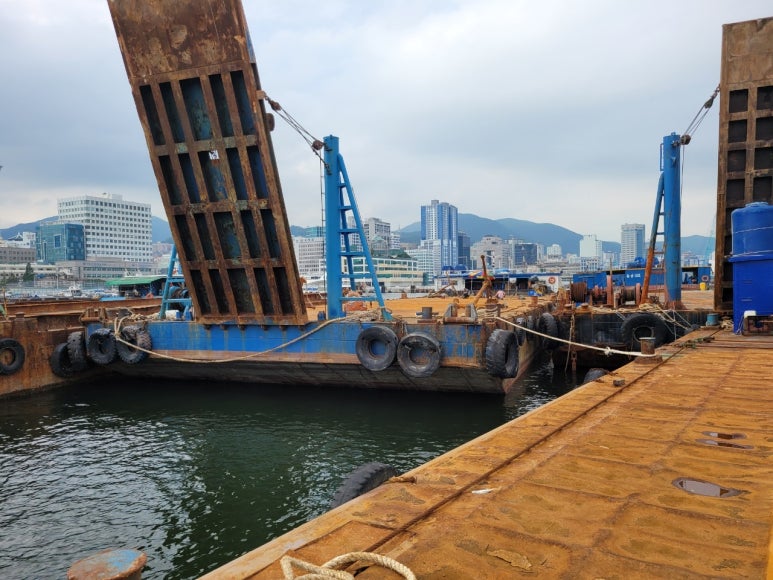 A ramp-equipped barge moored at a port